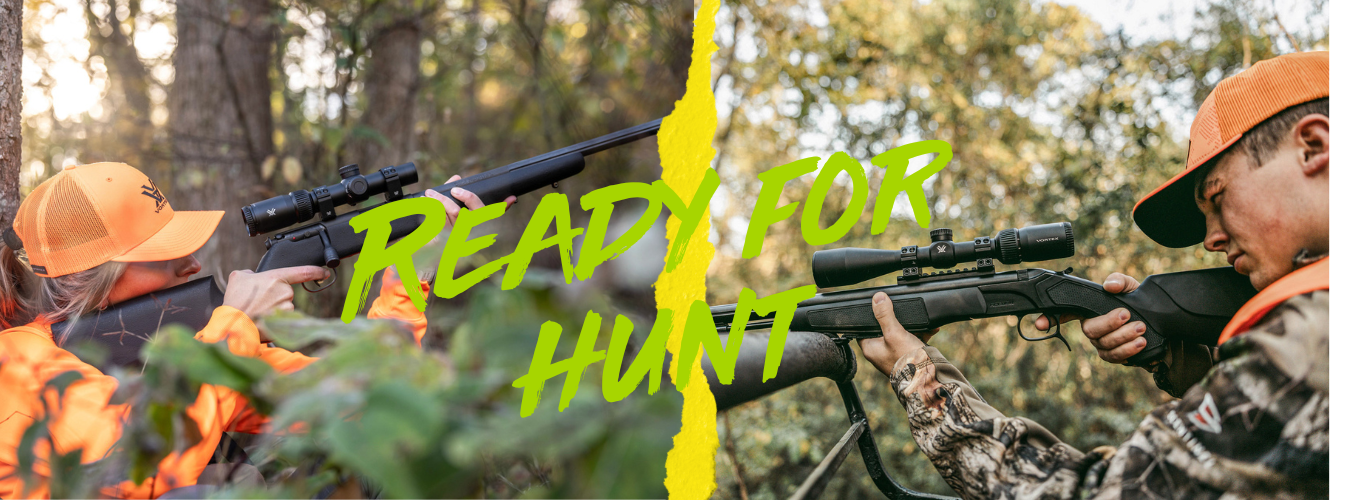 Zwei Jäger mit orangener Kleidung und Gewehren im Wald