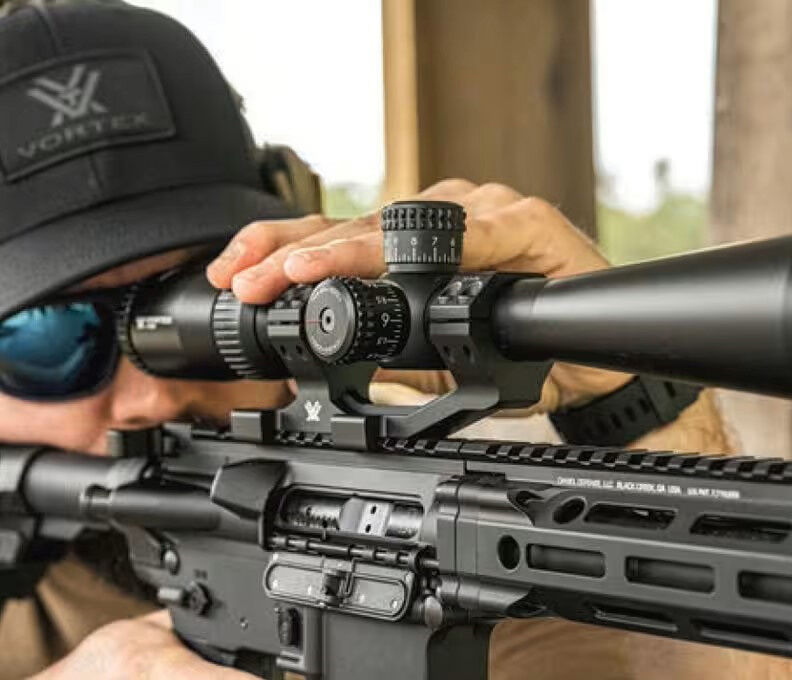 Präzise Zielerfassung mit einem hochwertigen Zielfernrohr Person justiert ein Zielfernrohr auf einem Gewehr für präzises Zielen