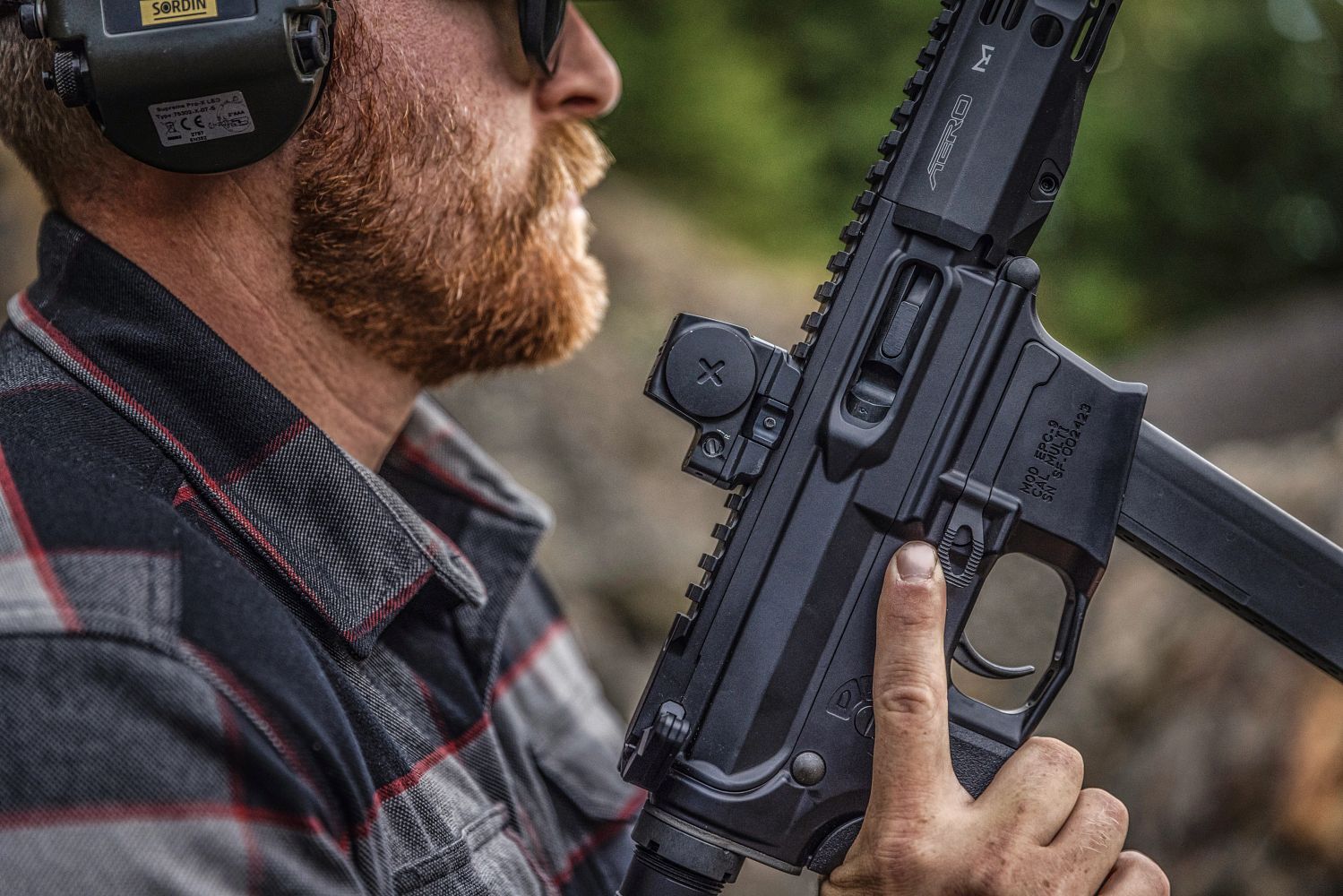 Nahaufnahme Mann mit Gehörschutz hält halbautomatische Waffe