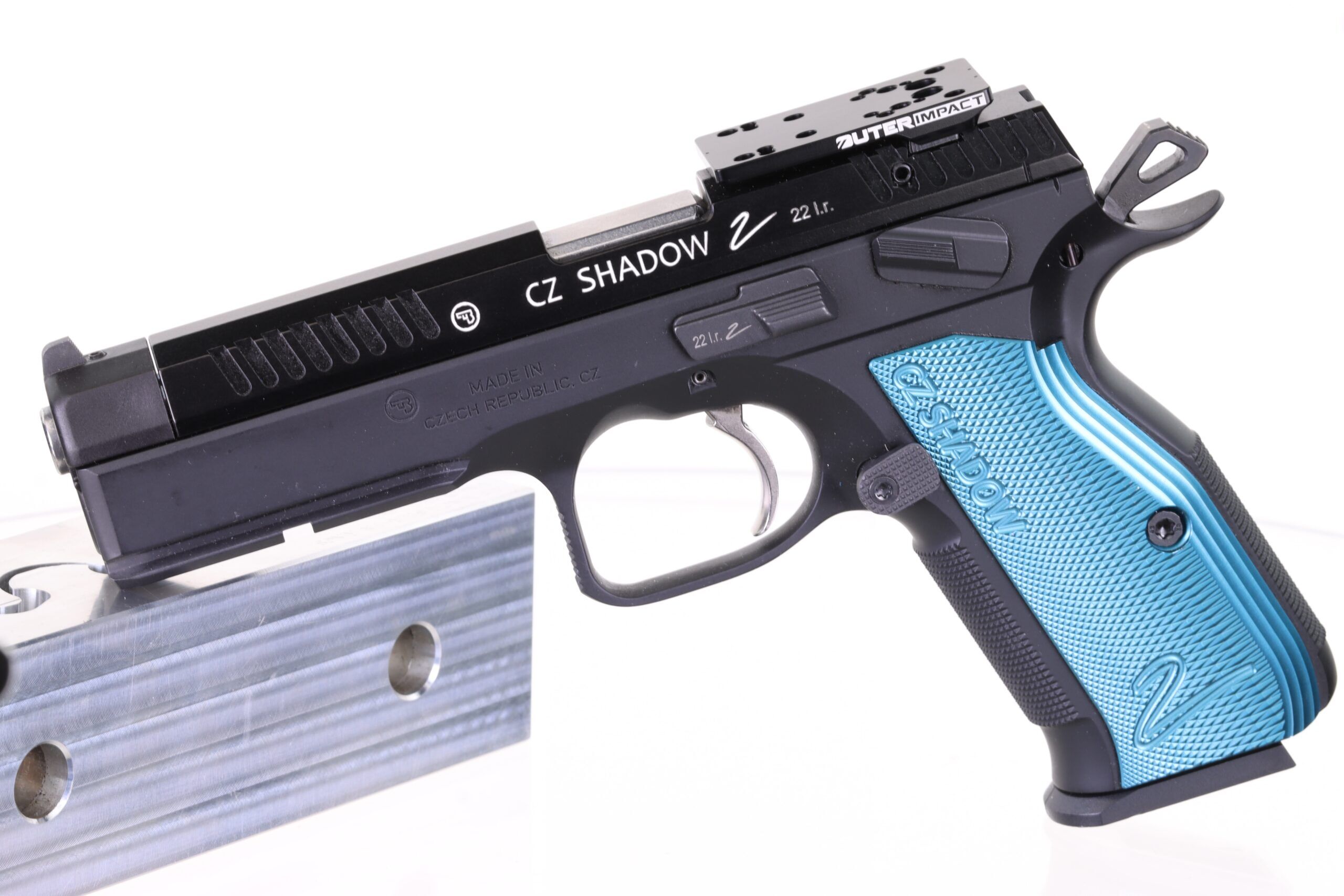 Seitliche Ansicht der CZ Shadow 2 Pistole mit charakteristischem blauem Griff und Optik-Setup, platziert auf einem Metallständer