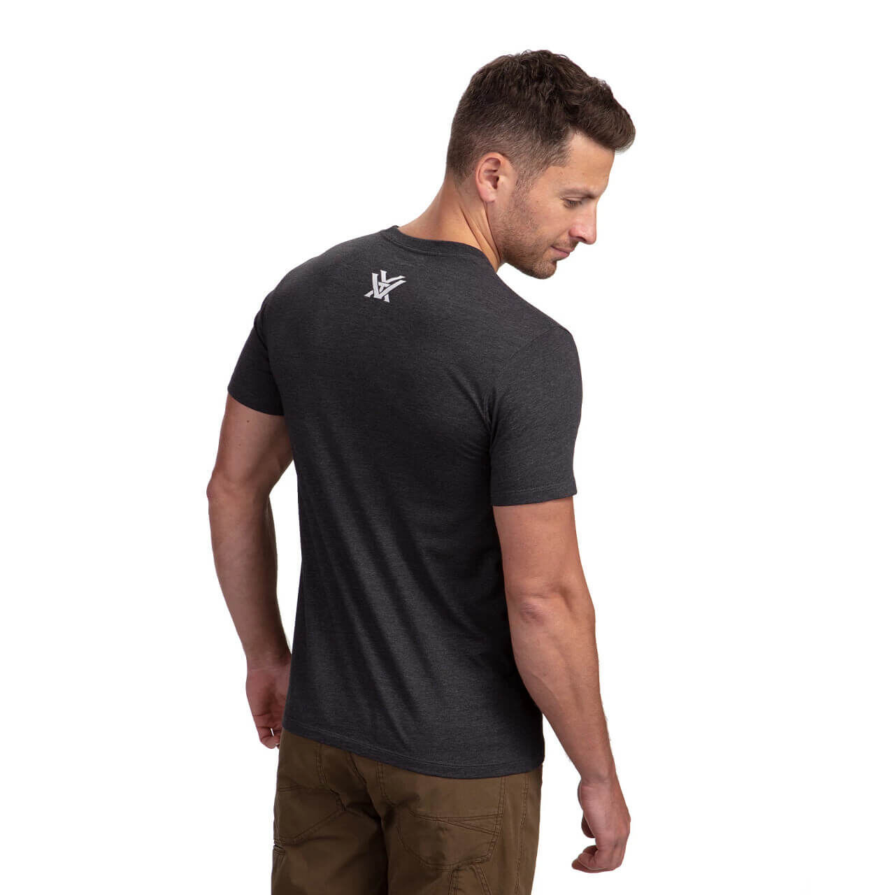 Rückansicht eines Mannes im dunkelgrauen T-Shirt mit Logo, kombiniert mit brauner Hose